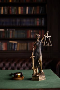 Lady Justice and gavel on a table in a classic law library setting.